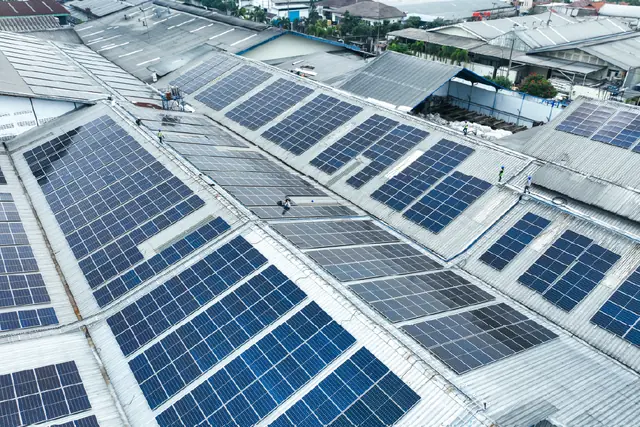 Panel surya di atap pabrik dilihat dari udara