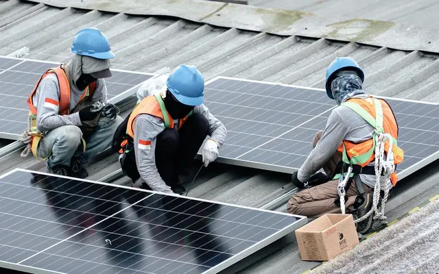 Teknisi memasang panel surya di atap