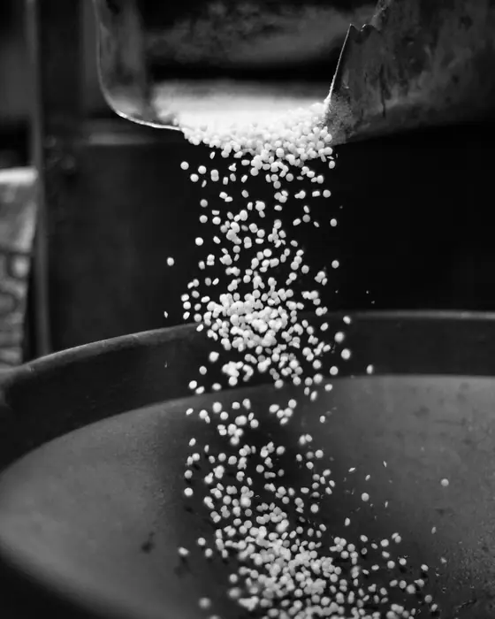 Biji plastik daur ulang jatuh dari corong