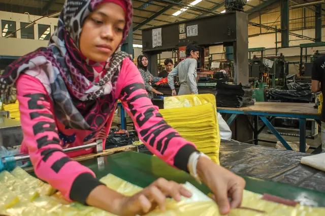 Pekerja merapikan kantong plastik