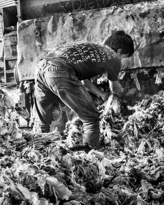 Pekerja memilah tumpukan plastik bekas